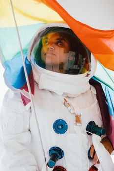 一个身穿太空服的人自豪地举起彩虹骄傲旗，象征着多样性与探索
