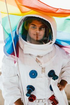 宇航员身穿宇航服，在室内举着彩虹骄傲旗的肖像
