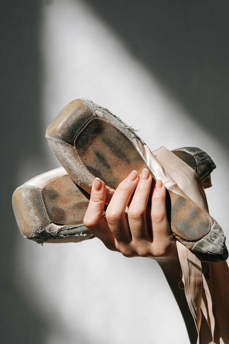 A Person Holding A Pointe Shoes