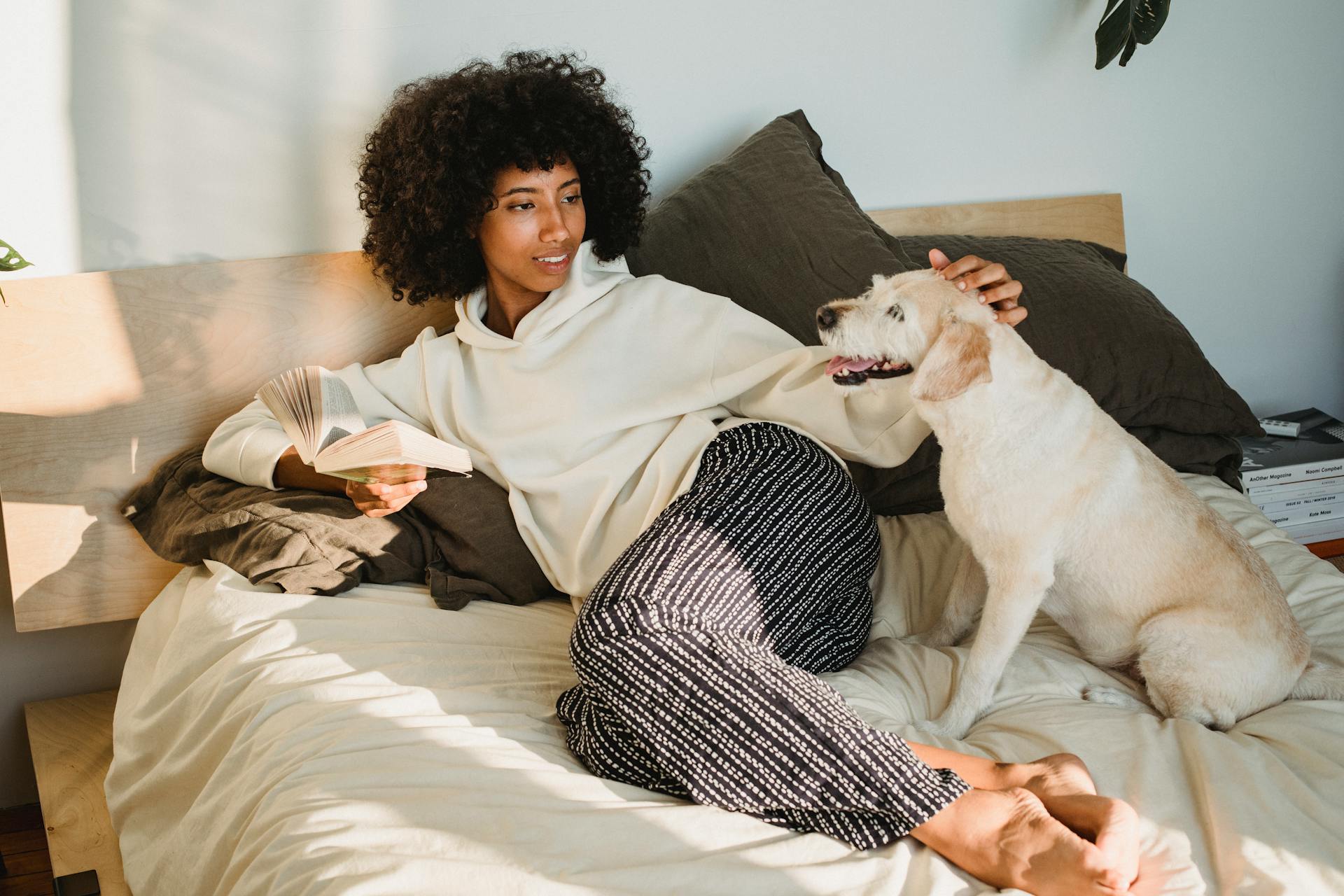 Woman Sitting on Bed Beside Her Dog