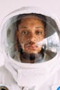 一名男子戴着逼真的宇航员头盔，直视摄像机的特写镜头