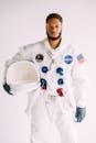 一名身穿美国宇航局宇航员服装的男子在工作室手持头盔摆姿势