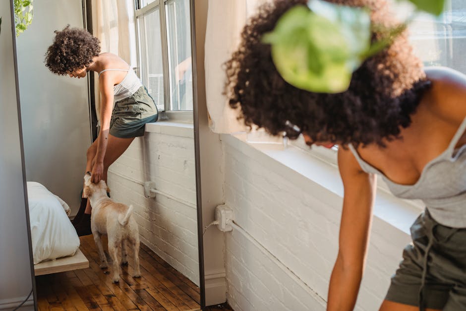 Avocado Green vs Birch Natural: Organic Cert Showdown A woman with curly hair interacts playfully with her dog in a well-lit bedroom.