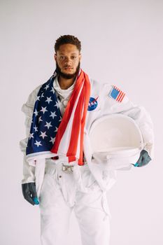 宇航员穿着太空服，戴着头盔，头盔上覆盖着美国国旗，背景为白色