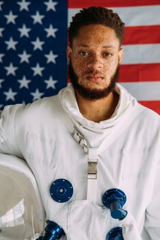 一个穿着太空服的男人站在美国国旗前的肖像