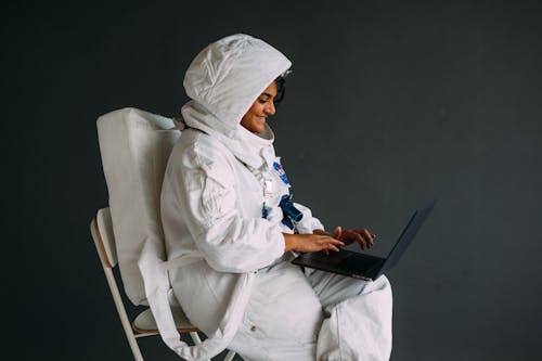 Frau In Einem Raumanzug Unter Verwendung Eines Laptops