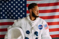 以美国国旗为背景，一名身穿宇航服的男子肖像代表了美国宇航局