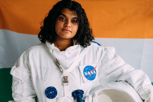Free Portrait of an Indian woman in a NASA spacesuit against a colorful backdrop. Stock Photo