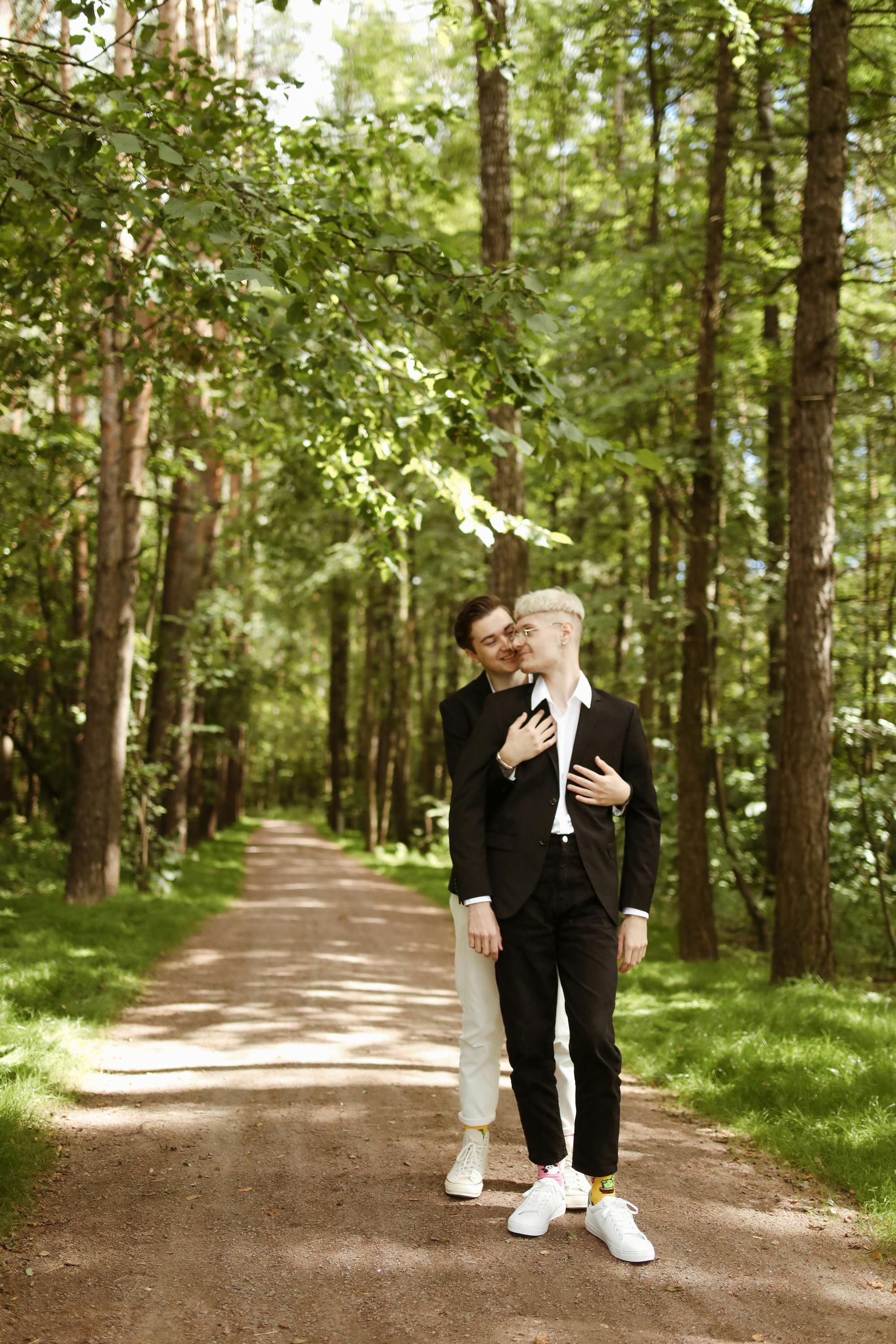 couple standing on the unpaved pathway in the woods