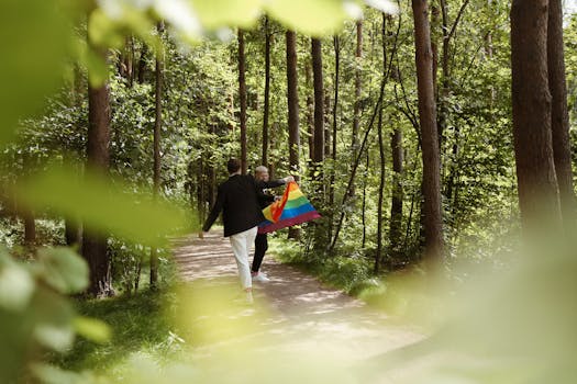 两名男子举着彩虹旗，一同走在森林中，象征着爱与多样性