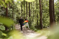 一对夫妇手持鲜艳的彩虹旗，在森林中行走，象征着爱与自豪