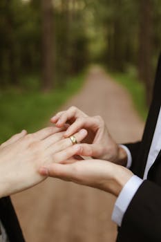 A touching moment of a gay couple exchanging rings on a lush outdoor path.