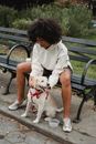 一位女士和她的狗在公园长椅上享受休闲时光，展现出一种深情的纽带