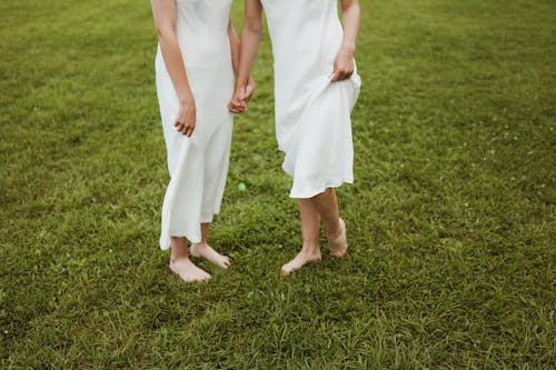 Women in White Dress Standing on Green Grass Field