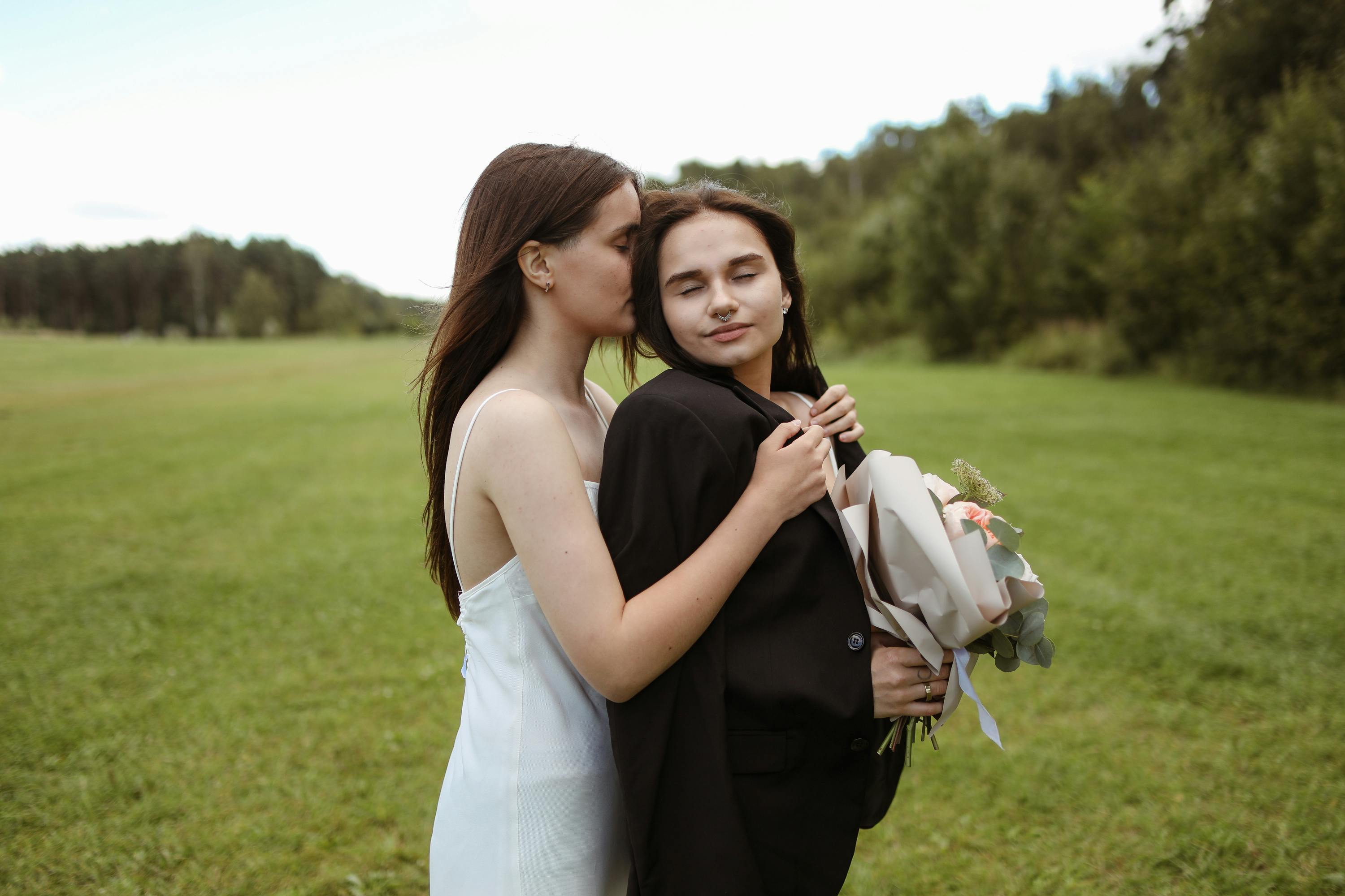 women with bouquet showing affection