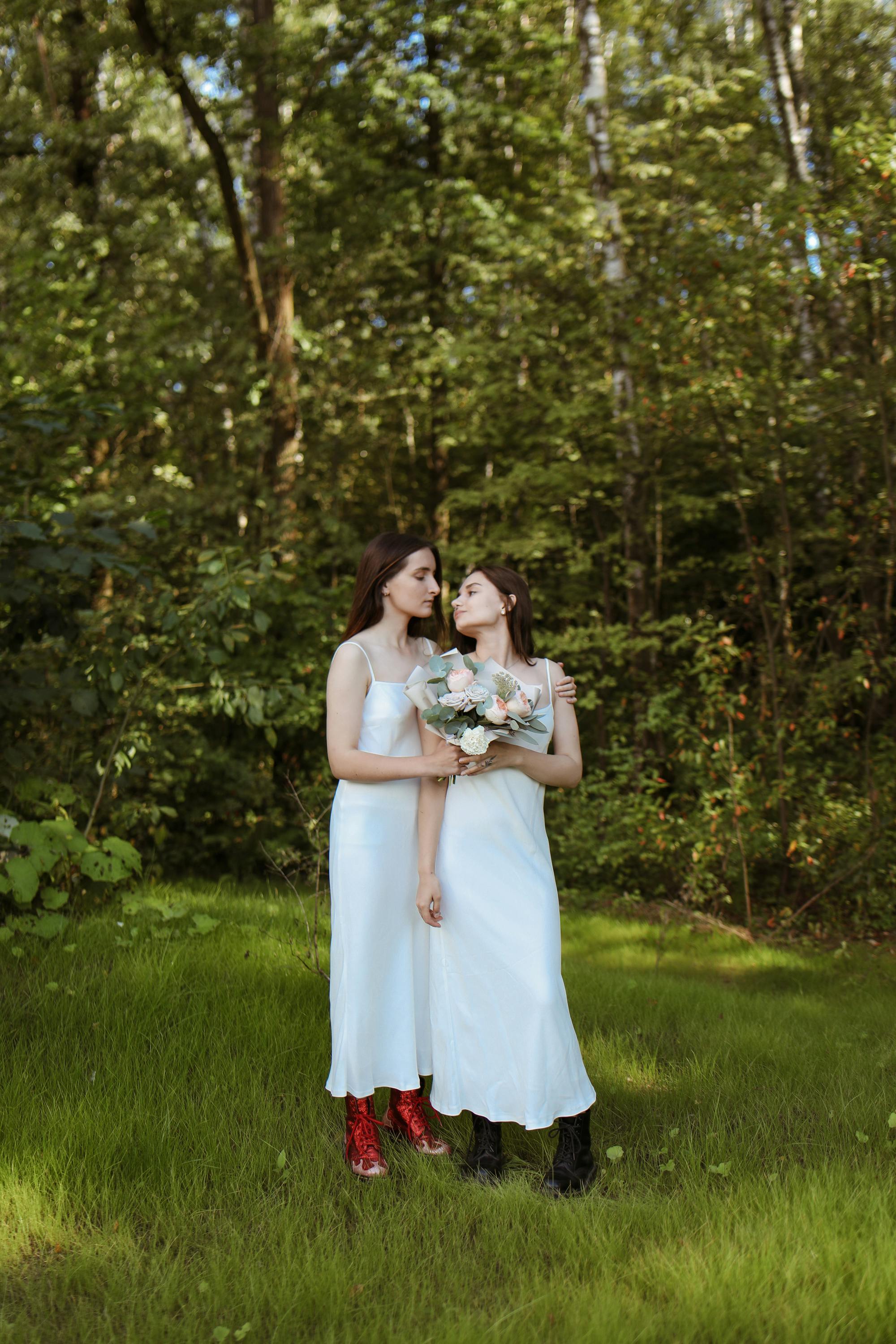 women in white dress standing on green grass field