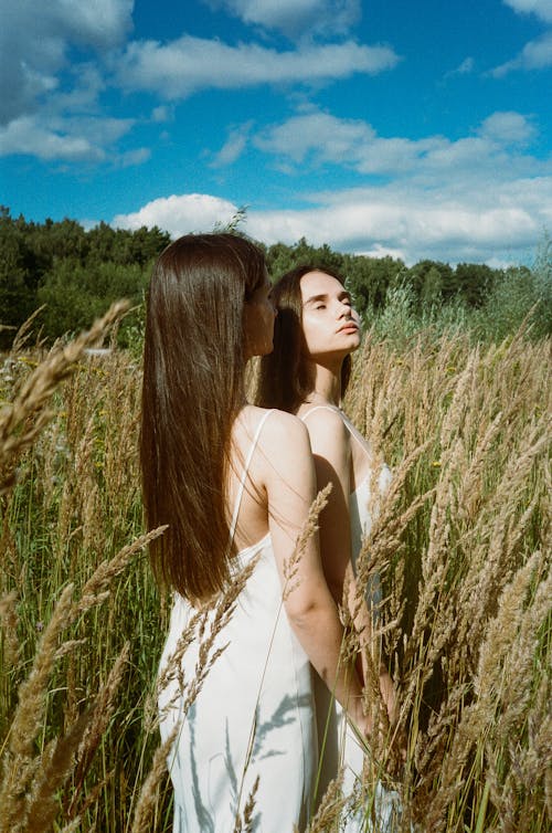 Women in White Spaghetti Dress Standing on Brown Grass Field