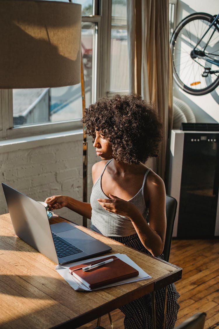 Black Remote Worker With Laptop And Coffee At Table Indoors