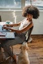 African American woman working on computer with dog near