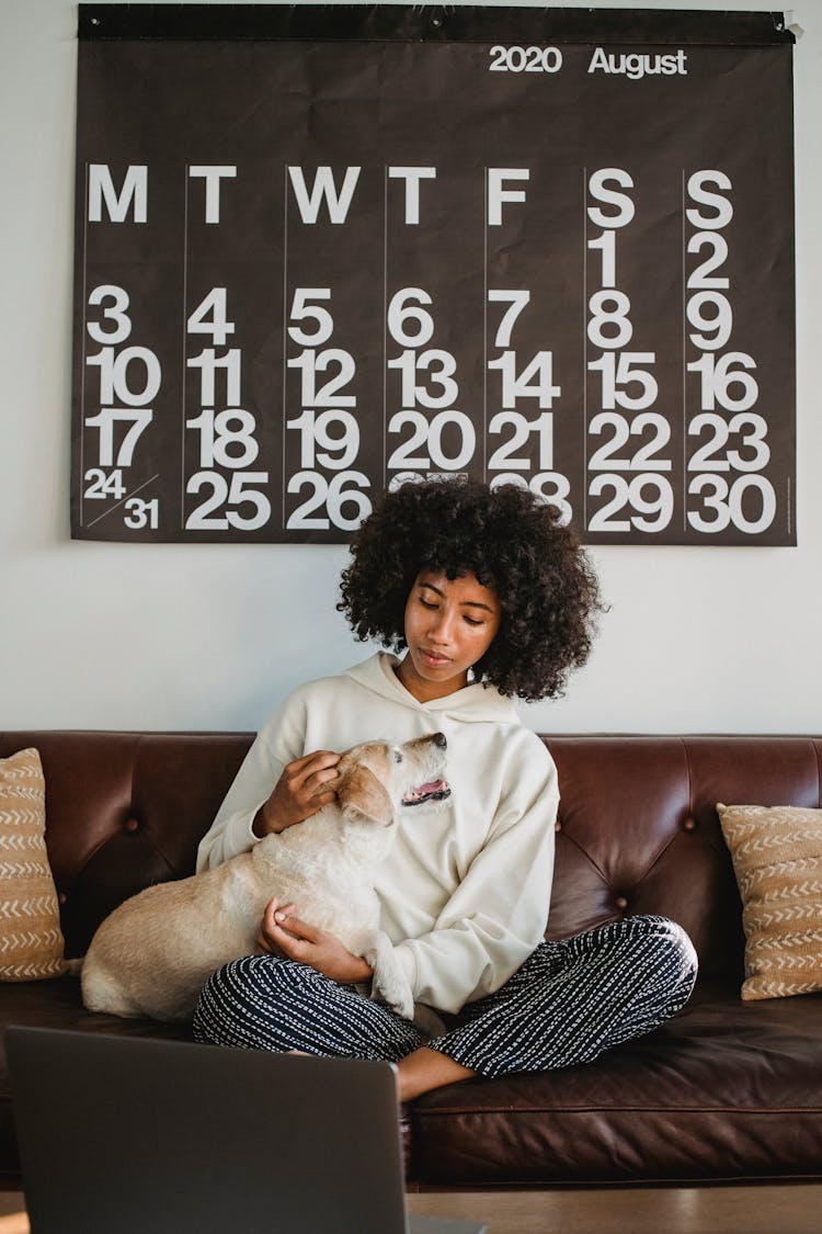 Black Woman Petting Dog On Couch