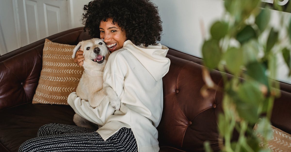 Smiling African American lady cuddling with dog in living room