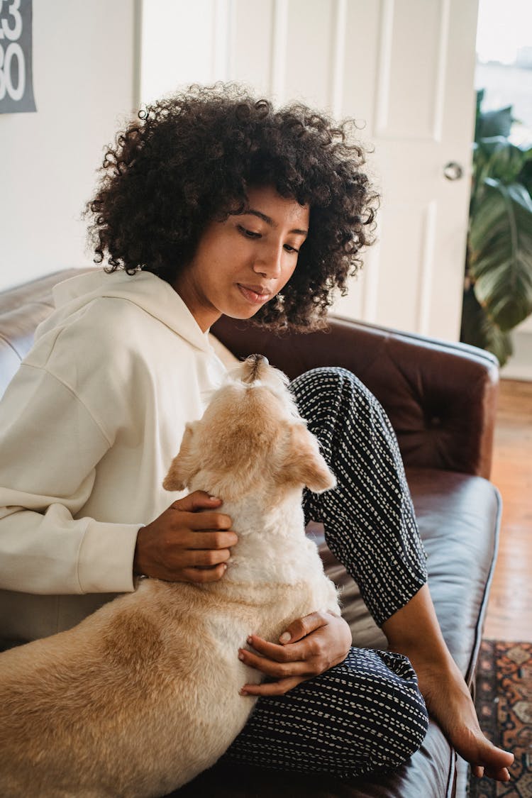 Black Female Hugging With Dog In Living Room