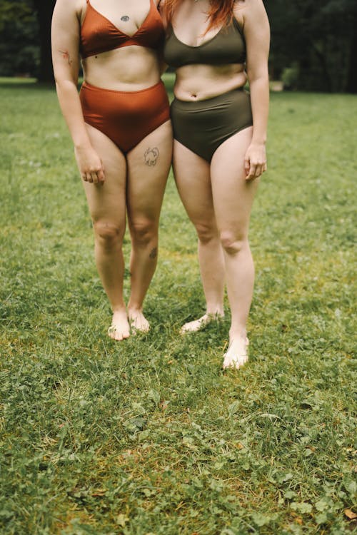 Women Wearing Bathing Suit Standing on Green Grass Field