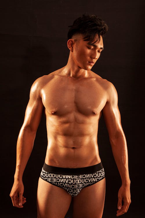 A Shirtless Man in Printed Underwear with His Eyes Closed