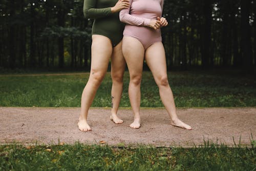 Women in Bodysuits Standing Barefooted on a Concrete Floor