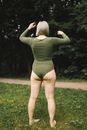 Woman in Green Long Sleeve Shirt and Black Panty Standing on Green Grass Field