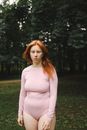 Woman in Pink Long Sleeve Shirt Standing on Green Grass Field