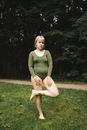 Woman in Green Long Sleeve Shirt Sitting on Green Grass Field