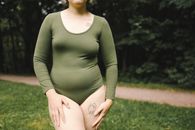 Pregnant Woman in Green Long Sleeve Shirt and Pink Pants