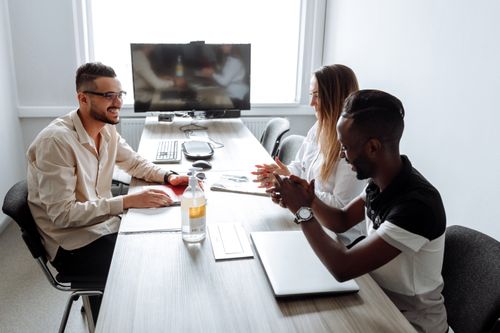Free Corporate meeting with diverse professionals discussing strategies in a modern office setting. Stock Photo
