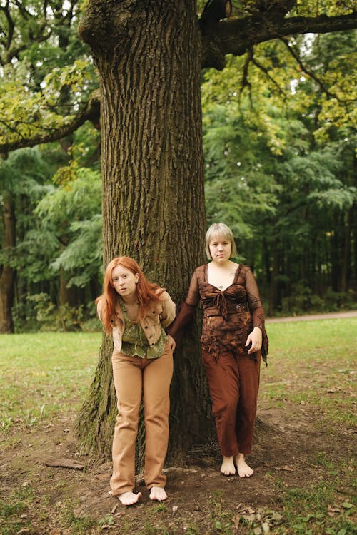 Women Standing Barefoot in front of a Tree