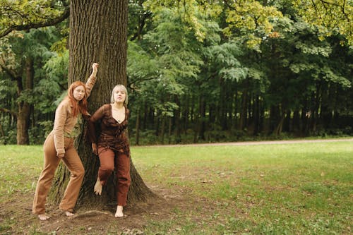 Women Leaning on the Tree while Standing Barefooted on the Ground