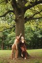 Woman in Brown Dress Standing Beside Tree