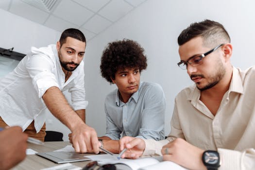 Three professionals engaged in a collaborative business meeting indoors.