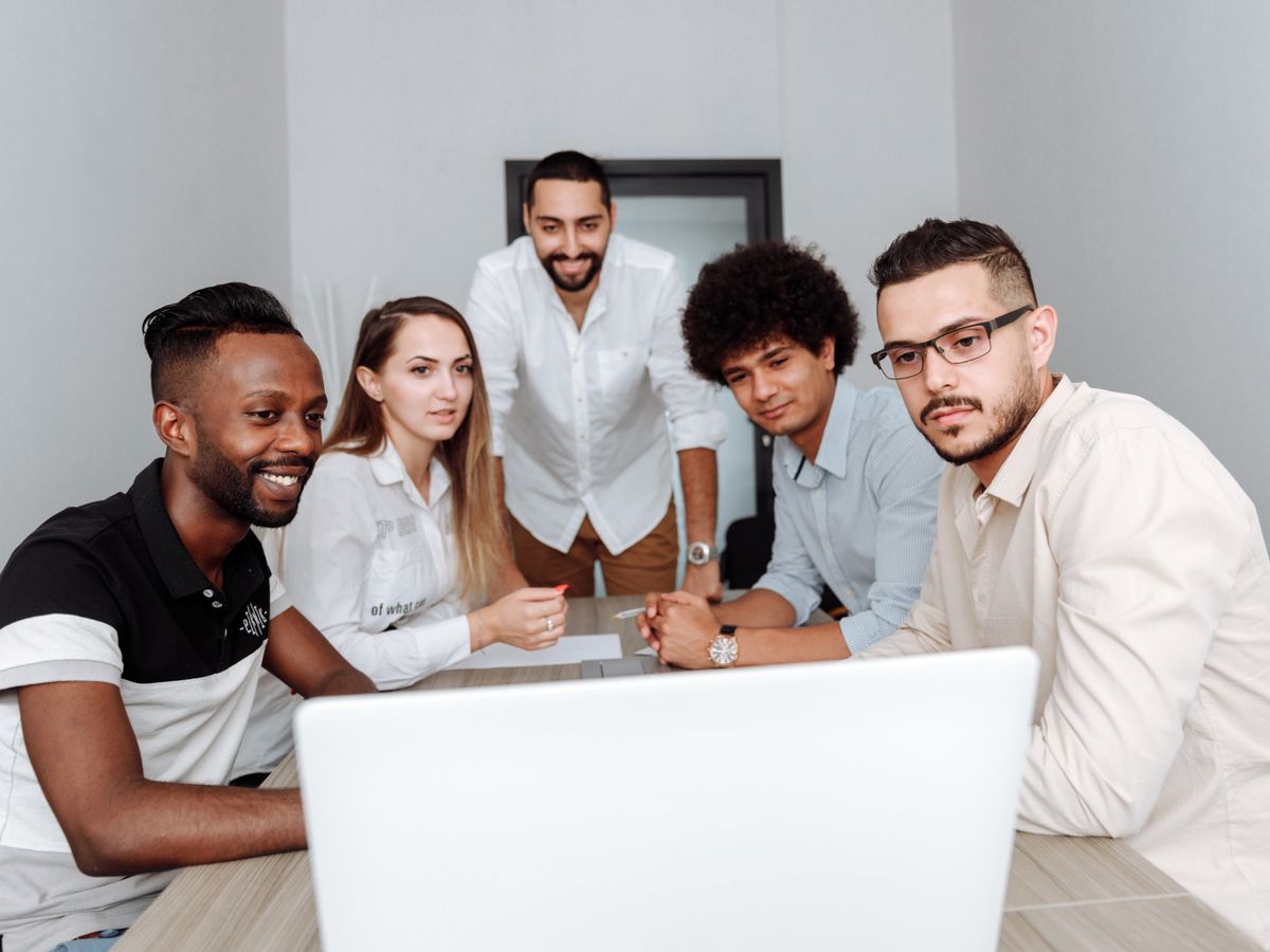 A diverse team discussing professional development around a laptop