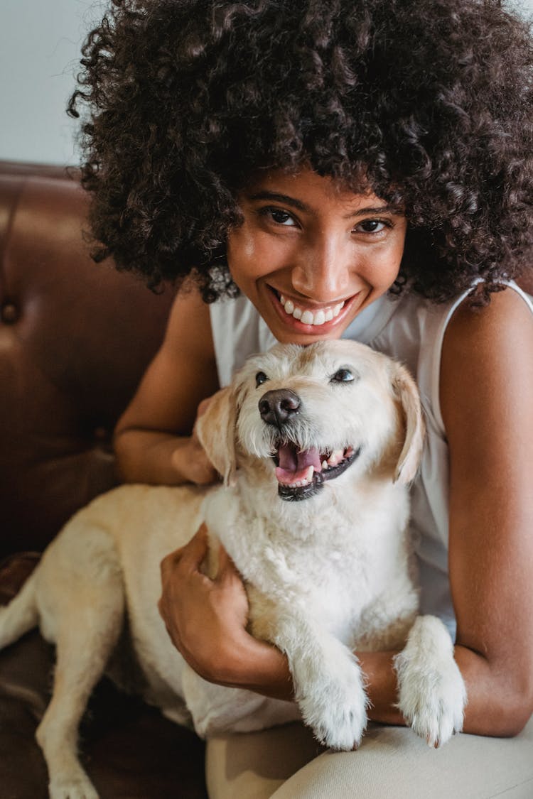 Happy Black Woman Embracing Cute Puppy