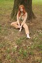 Woman in Brown Long Sleeve Shirt and Brown Pants Sitting on Ground