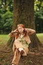 Woman in Brown Coat Standing Beside Tree