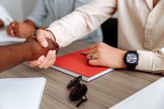 A handshake over documents at a desk — photo by Thirdman on Pexels