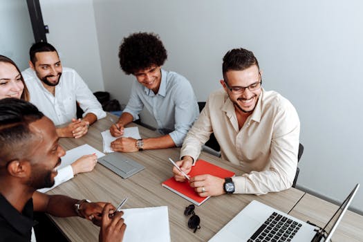 A group of diverse professionals collaborating during a team meeting in a modern office setting.
