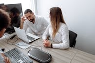 Woman in White Long Sleeve Shirt Sitting Beside Man in White Dress Shirt