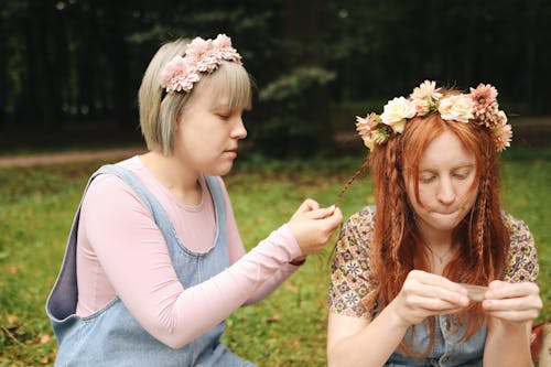 A Woman Braiding Her Friends Hair 