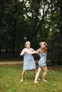 Woman in Blue Dress Holding Girl in White Dress on Green Grass Field