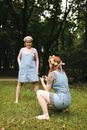 Woman in Blue Dress Sitting on Green Grass Field