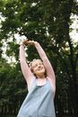 Woman in Blue Tank Top Raising Her Hands