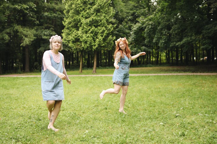 Playful Friends Hopping Barefoot On Grass